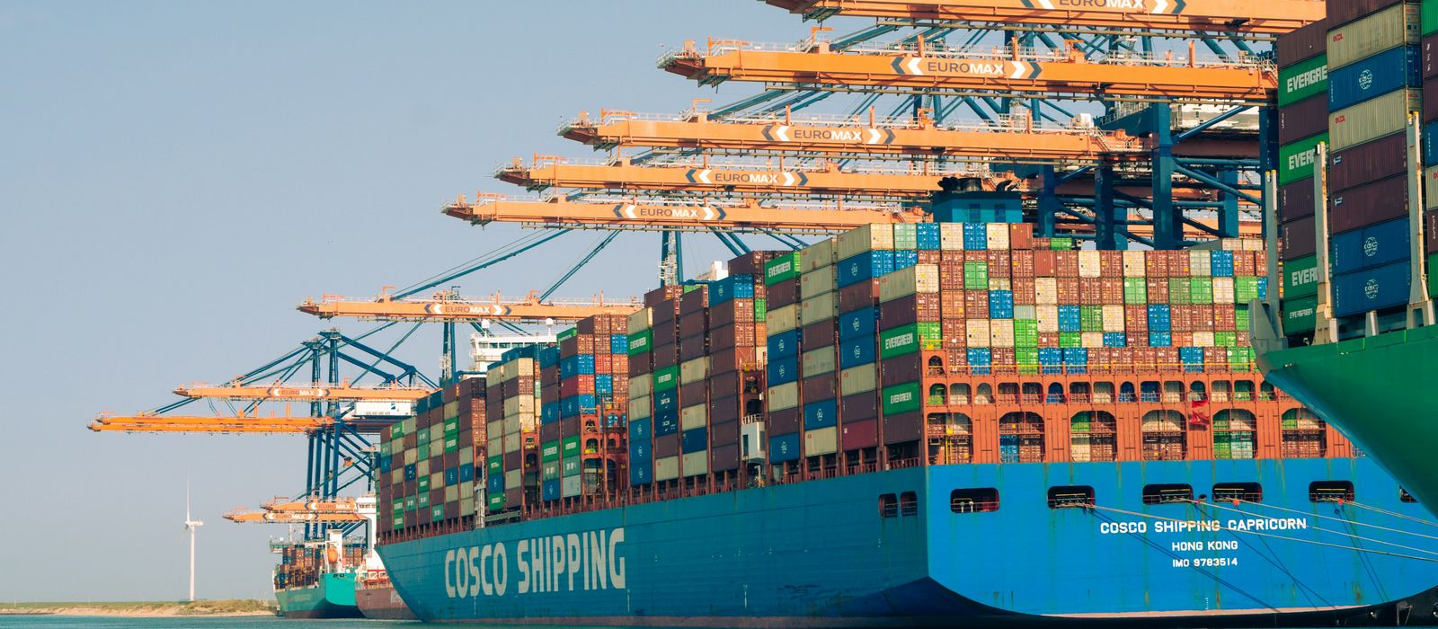 Container ship moored beside quayside cranes in a large port