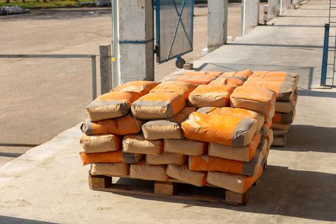 A pallet of cement bags stacked in a yard